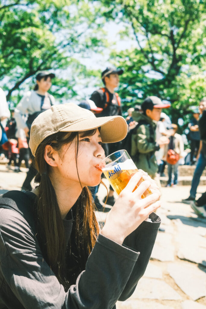 高尾山山頂で飲むビールを飲む彼女